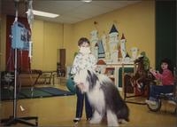 Old English sheepdog visiting with young patients in the rehabilitation room of the hospital